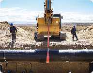 men standing next to a pipe inspecting the construction of pipeline